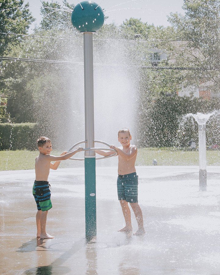 Deux petits garçons s'amusent aux jeux d'eau du parc Brunet d'Amos.